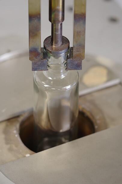 Die Flasche wird in ein Salzbad gesenkt. Die Flasche wird in ein Salzbad gesenkt.