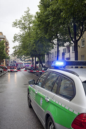 Der geknickte Baum hängt schräg über der Straße. Stabil sieht das nicht aus. Darunter und gegenüber parken Autos.