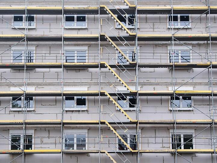 Ein Baugerüst steht an einem Neubau. Foto: Julian Stratenschulte/dpa/Archiv