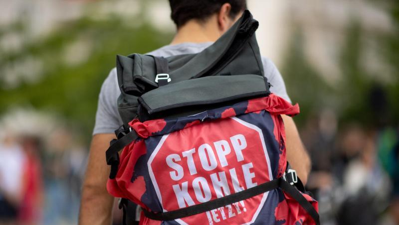 Ein Teilnehmer einer "Fridays for Future"-Klimademonstration hat an seinem Rucksack ein Transparent mit der Aufschrift "Stopp Kohle jetzt!" befestigt. Ein Teilnehmer einer "Fridays for Future"-Klimademonstration hat an seinem Rucksack ein Transparent mit der Aufschrift "Stopp Kohle jetzt!" befestigt.