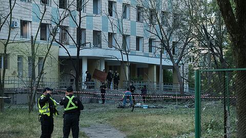 Polizisten in Kiew inspiziert ein Gebäude, das bei einem russischen Nachtangriff beschädigt wurde.