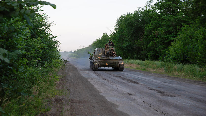 Ukrainische Soldaten fahren auf der Straße in einem gepanzerten Fahrzeug außerhalb von Bakhmut. Ukrainische Soldaten fahren auf der Straße in einem gepanzerten Fahrzeug außerhalb von Bakhmut.