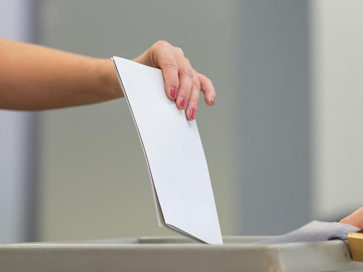 Ein Wahlzettel wird in eine Wahlurne geworfen. Foto: Robert Michael/dpa-Zentralbild/dpa/Symbolbild