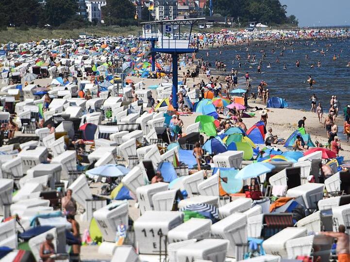 Hunderte Touristen besuchen einen Strand an der Ostsee auf der Insel Usedom.