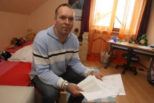 Peter G. sitzt mit seinen Unterlagen im leeren Kinderzimmer.