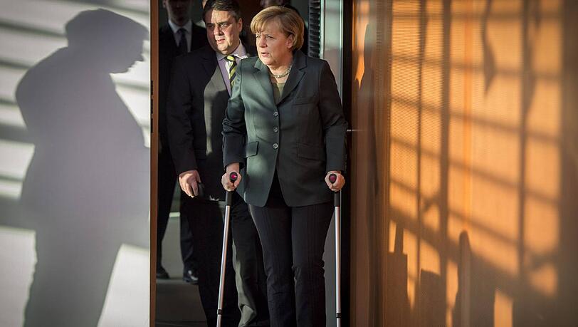 Auf Krücken betritt Kanzlerin Angela Merkel den Kabinetts-Saal. Vizekanzler Sigmar Gabriel trägt ihr die Papiere. Auf Krücken betritt Kanzlerin Angela Merkel den Kabinetts-Saal. Vizekanzler Sigmar Gabriel trägt ihr die Papiere.