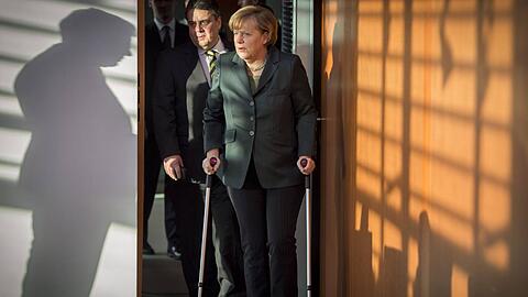 Auf Krücken betritt Kanzlerin Angela Merkel den Kabinetts-Saal. Vizekanzler Sigmar Gabriel trägt ihr die Papiere.