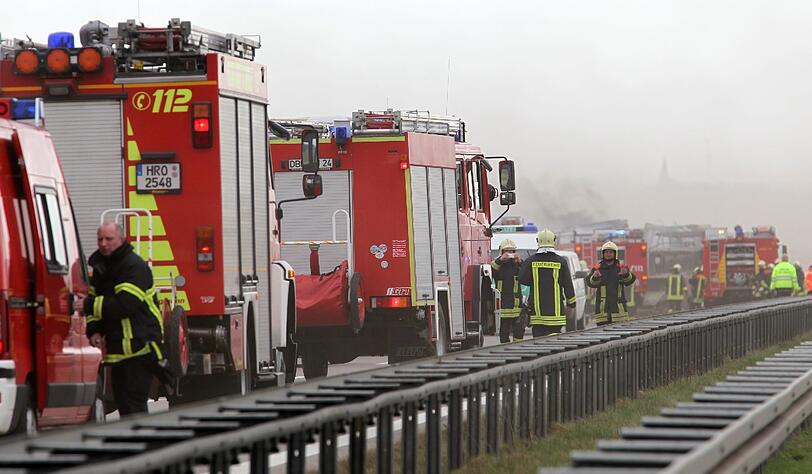 Feuerwehrleute sind am Freitag auf der Autobahn A19 bei Kavelstorf in der Nähe von Rostock bei einer Massenkarambolage im Einsatz. Bei einem Sandsturm fuhren in beiden Fahrtrichtungen Dutzende Fahrzeuge und LKW ineinander und brannten teilweise aus.