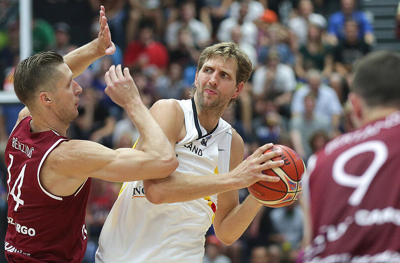 Lettlands Dairis Bertans (l-r), Lettlands Kaspars Berzins (l) und Deutschlands Superstar Dirk Nowitzki kämpfen um den Ball.