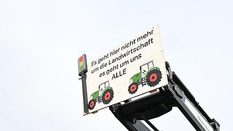 Mit Traktoren und einem Transparent mit der Aufschrift: "Es geht hier nicht mehr um die Landwirtschaft es geht um uns ALLE" demonstrieren Landwirte mit Traktoren gegen die Agrarpoltik der Bundesregierung.
