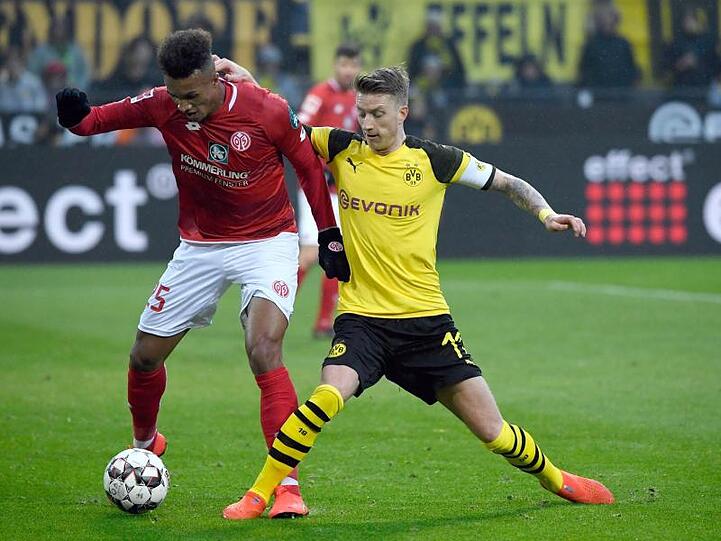 BVB-Kapitän Marco Reus (r) beim Zweikampf mit dem Mainzer Jean-Philippe Gbamin.