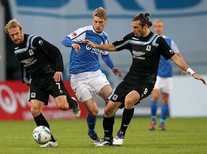 Zangengriff: Daniel Bierofka (l) und Djordje Rakic (r) trennen den Rostocker Michael Blum (M) vom Ball.