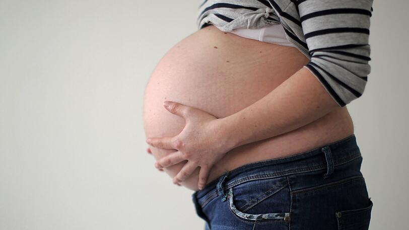 Eine schwangere Frau hält ihren Bauch. (Symbolbild)