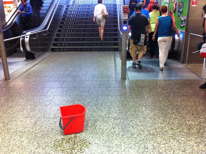 ... vor der Rolltreppe zur Bahnhofshalle auf dem Boden. Alle Passanten...