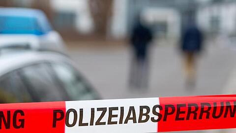 Ein Polizeiabsperrband vor einem Polizeiwagen. Foto: Marc Tirl/ZB/dpa/Symbolbild