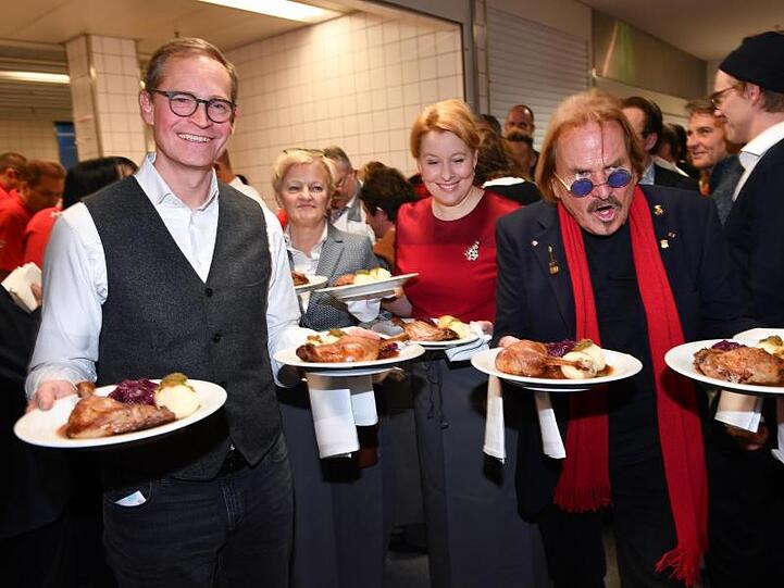 Michael Müller, Renate Künast, Franziska Giffey und Frank Zander servieren im Hotel Estrel Gänsebraten für die Gäste.