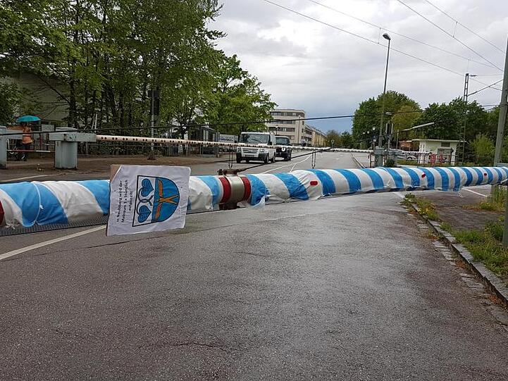 Eine Bahnschranke ist mit weiß-blauem Stoff umwickelt. Foto: Cordula Dieckmann/dpa