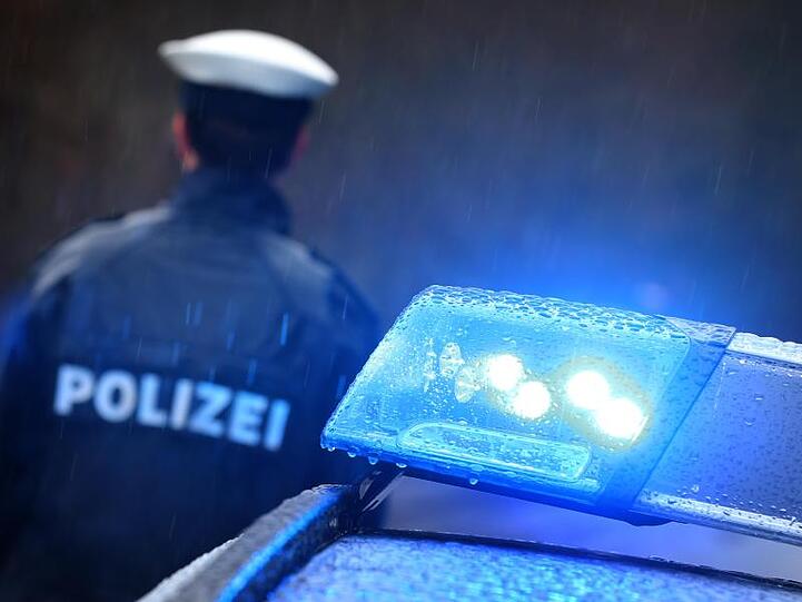Ein Polizist steht vor einem Streifenwagen. Foto: Karl-Josef Hildenbrand/dpa/Symbolbild