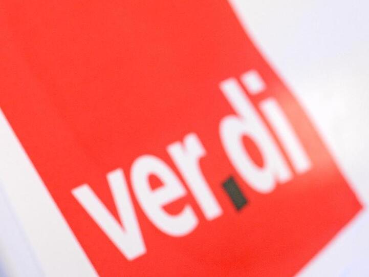 Ein Mann bei einem Warnstreik vor dem roten Verdi-Logo. Foto: Patrick Seeger/Archivbild