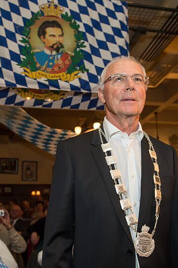 "Kaiser" Franz Beckenbauer steht im Fürstlichen Brauhaus Thurn und Taxis in Regensburg mit der Salvator-Traditionskette vor einer Fahne mit einer Abbildung von König Ludwig II.