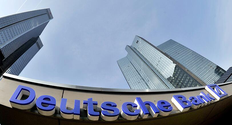Verzerrt spiegelt sich in Frankfurt am Main das Logo der Deutschen Bank in einer Glasfassade.
