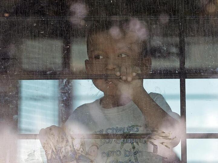 Ein Kleinkind aus einer Familie illegaler Migranten an der Grenze zwischen Mexiko und den USA hinter dem Fenster eines Busses.