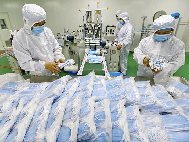 Arbeiter verpacken Schutzmasken: Die Zahl neuer Infektionen ist in China erneut gestiegen.