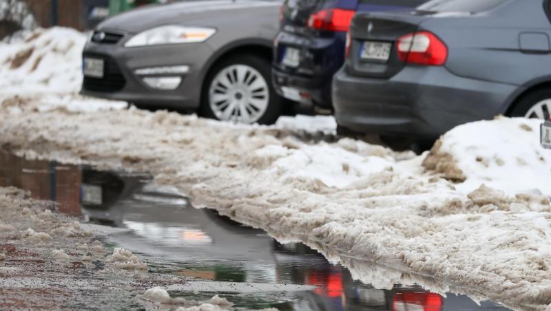 Autos parken - wie hier in Halle - zwischen Schneehaufen. Das einsetzende Tauwetter hält auch bis zum Ende der Woche an.