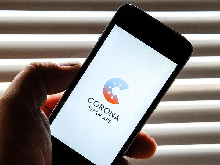 Auf dem Bildschirm eines Apple iPhone SE ist der vom Presse- und Informationsamt der Bundesregierung herausgegebene Startschirm einer Corona Warn-App abgebildet.
