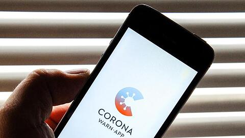 Auf dem Bildschirm eines Apple iPhone SE ist der vom Presse- und Informationsamt der Bundesregierung herausgegebene Startschirm einer Corona Warn-App abgebildet.
