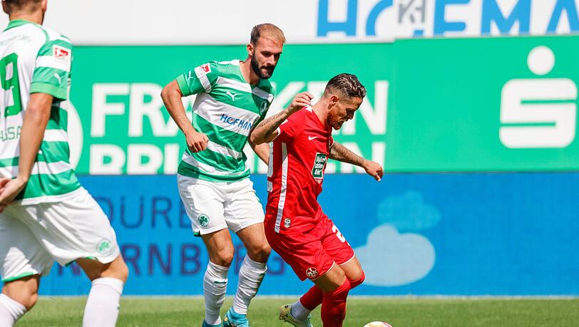 Der Kaiserslauterner Mike Wunderlich (r) geht am Fürther Simon Asta (l) vorbei und macht die Vorlage zum 1:1-Ausgleich.