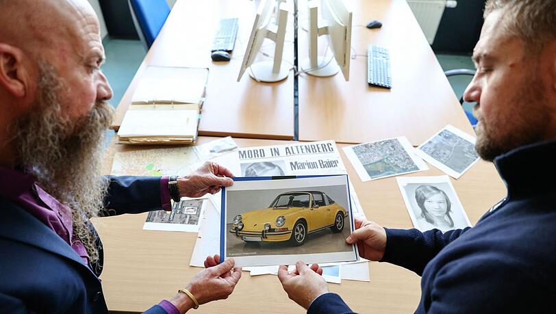 In solch einem Auto - das Bild ist KI-generiert - soll der T&auml;ter laut Zeugenaussagen mit Marion Baier vor der Tat gestritten haben. Gehalten wird es von Patrick Merten (r), Leiter des Cold Case &bdquo;Marion Baier&ldquo; und Michael Dietsch, Leiter der Kripo F&uuml;rth.