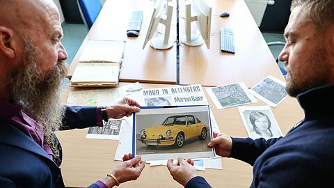 In solch einem Auto - das Bild ist KI-generiert - soll der T&auml;ter laut Zeugenaussagen mit Marion Baier vor der Tat gestritten haben. Gehalten wird es von Patrick Merten (r), Leiter des Cold Case &bdquo;Marion Baier&ldquo; und Michael Dietsch, Leiter der Kripo F&uuml;rth.