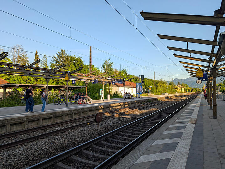 An den Bahnsteigen in Prien lässt die Bundesbahn ihre wartenden Fahrgäste im Regen stehen,