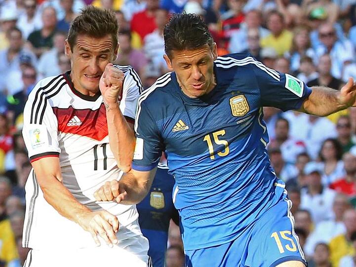 Miroslav Klose (l) und Martin Demichelis im Zweikampf. Foto: Diego Azubel/EPA/dpa/Archivbild