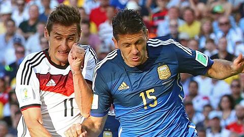 Miroslav Klose (l) und Martin Demichelis im Zweikampf. Foto: Diego Azubel/EPA/dpa/Archivbild