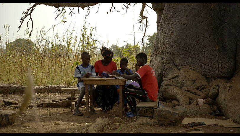Hausaufgaben im Schatten der Bäume in Ghana.