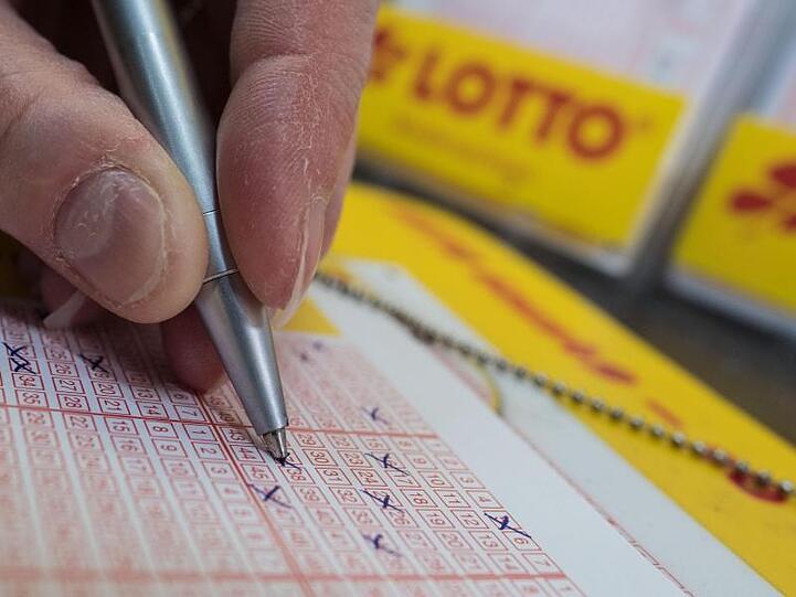 Ein Mann füllt einen Lottoschein aus. Foto: Peter Steffen/dpa