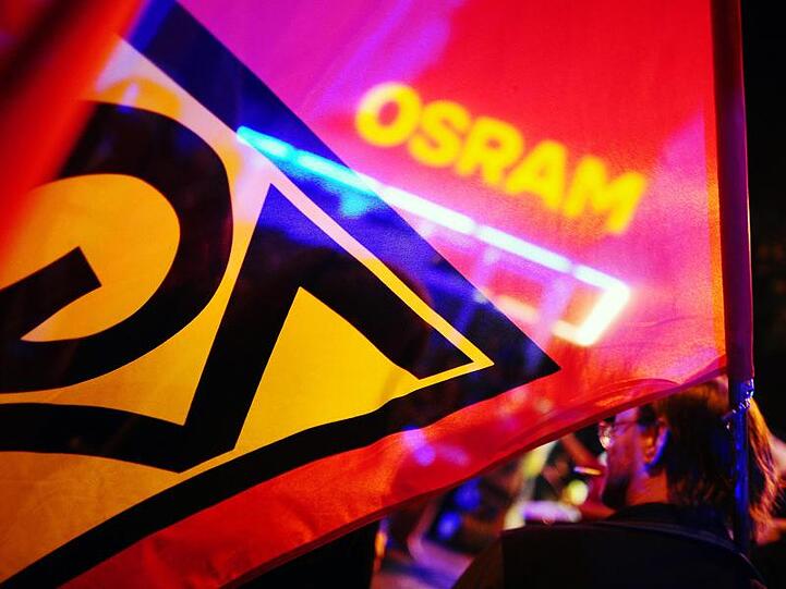 Gewerkschaftler demonstrieren vor dem Osram-Werk in Berlin. Foto: Michael Hanschke/dpa