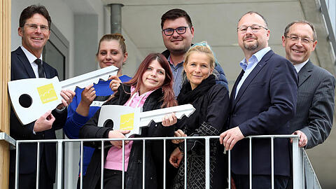 Gewofag-Chef Klaus-Michael Dengler (l.) und Sozialreferentin Dorothee Schiwy (3.v.r.) übergeben symbolisch Schlüssel an Mieterin Julia (2.v.l.).
