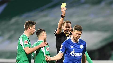 Schiedsrichter Sören Starke zeigt dem Schalker Klaas-Jan Huntelaar nach einem Foul die Gelbe Karte.