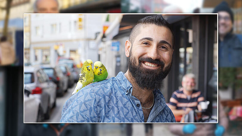 Koch Osman (26) mit seinen beiden Wellensittichen auf der Schulter.
"Ich gehe gerade mit meinen beiden Wellensittichen Sino und Ringo in der Müllerstraße spazieren, nachher geht es 
noch mit den beiden an die Isar. Ich weiß, dass sie nicht wegfliegen, sondern auf meiner Schulter sitzen bleiben  - sie sind sehr zahm.    
Die beiden sind Brüder - und sie lieben es, miteinander zu kuscheln. Ich habe die beiden aufgezogen. 
Mein Zuhause ist in Neuhausen - da habe ich sechs Vögel, darunter auch zwei singende Kanarienvögel. 
In der früh und in der Nacht sind meine Vögel ruhig. 
Ich liebe alle Tiere - Tauben mag ich auch gerne. Ursprünglich komme ich aus Syrien. 
Mein Stammlokal ist der Alpen Imbiss in der Thalkirchner Straße. Da gibt es tolle Thunfisch Pizza und ausgezeichneten Döner."