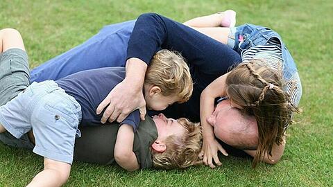 Prinz William tobt mit seinen drei Kindern im Gras.