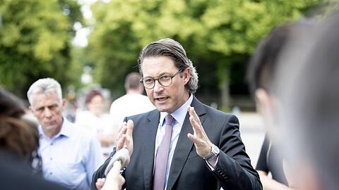 Bundesverkehrsminister Andreas Scheuer spricht bei der Protestaktion von Bus- und Touristikunternehmen am Brandenburger Tor mit Branchenvertretern und Journalisten.