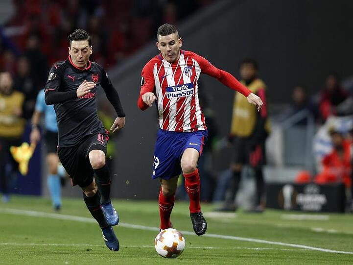 Lucas Hernández (r) von Atlético Madrid in Aktion gegen Mesut Özil.
