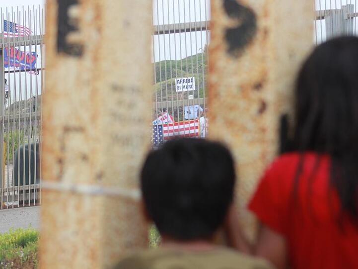 Blick nach drüben: Mexikanische Kinder beobachten durch den Grenzzaun Trump-Anhänger, die eine Verstärkung der Mauer fordern.