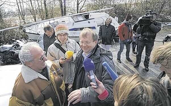 Reinhold Fischer umringt von Reportern. Im Hintergrund ist das Segelboot zu sehen, das er für 2600 Euro ersteigert hat. Foto: Feindt