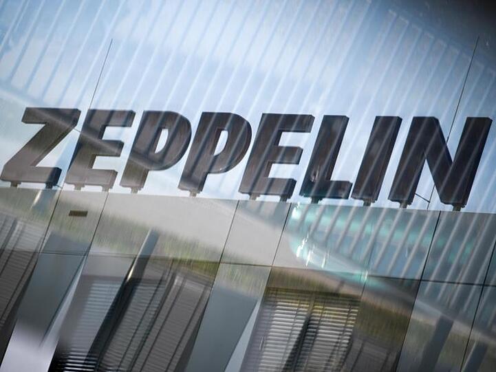 Das Logo des Zeppelin Konzerns ist durch eine Glasscheibe zu sehen. Foto: Felix Kästle/dpa/Symbolbild