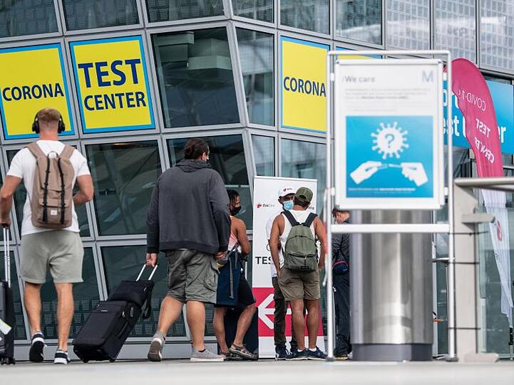 Ankommende Fluggäste gehen zu einem Corona- Testcenter am Flughafen München.