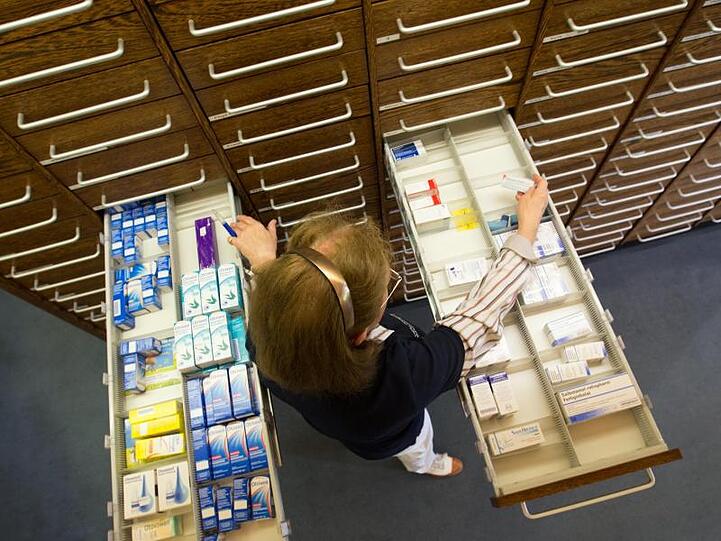 Eine Apothekerin steht in einer Apotheke vor einer ausgezogenen Medikamenten-Schublade. Foto: Friso Gentsch/Archiv